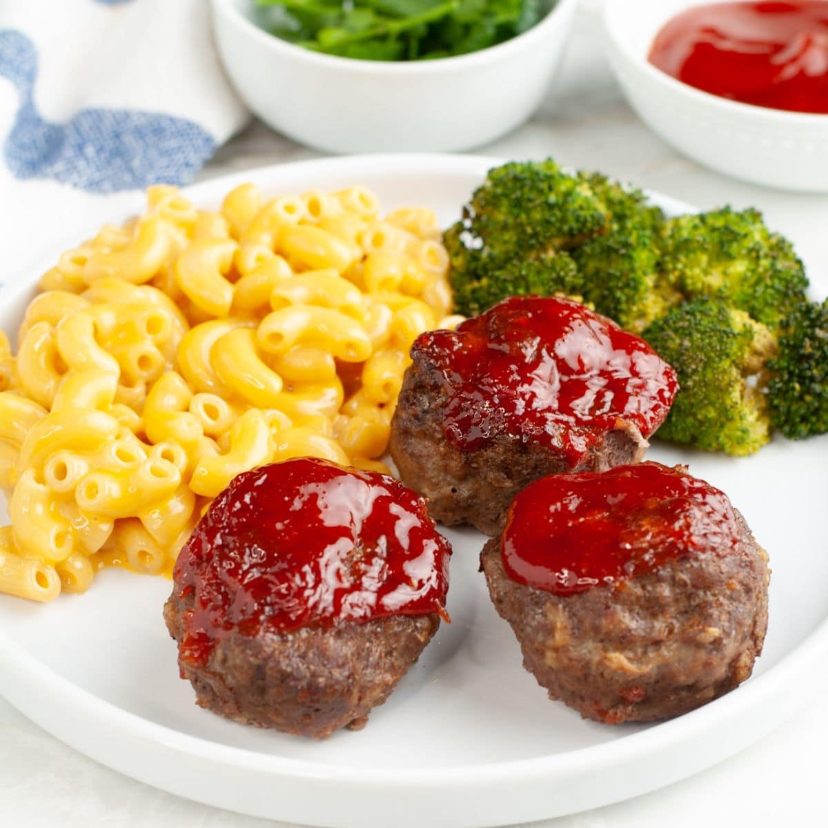 Plate with meatloaf muffins, mac and cheese, and broccoli.