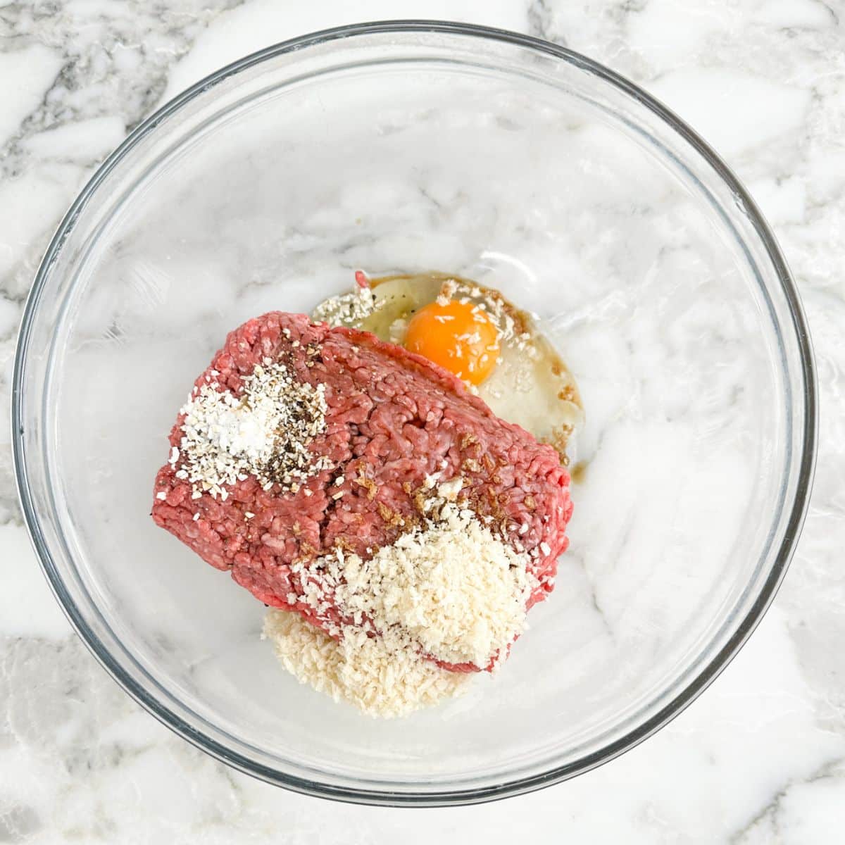 Bowl with ground beef, panko bread crumbs, egg, and seasonings.