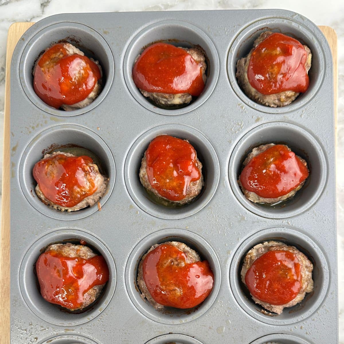 Mini meatloafs in a muffin tin.