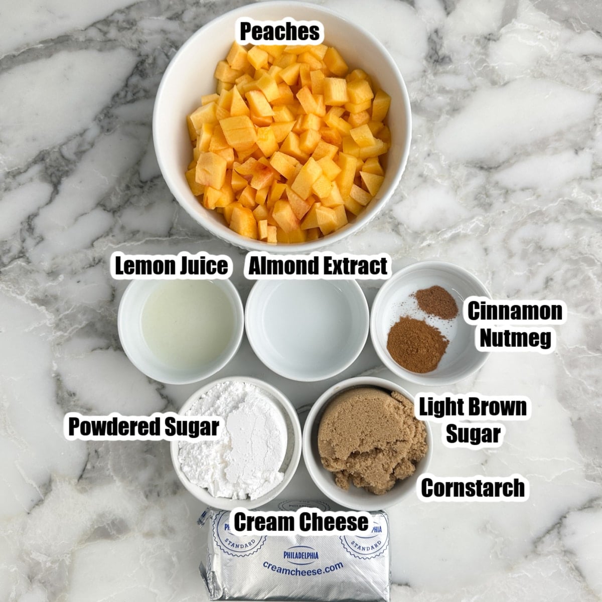 Bowl of diced peaches, lemon juice, almond extract, nutmeg, cinnamon, powdered sugar, brown sugar, cream cheese.