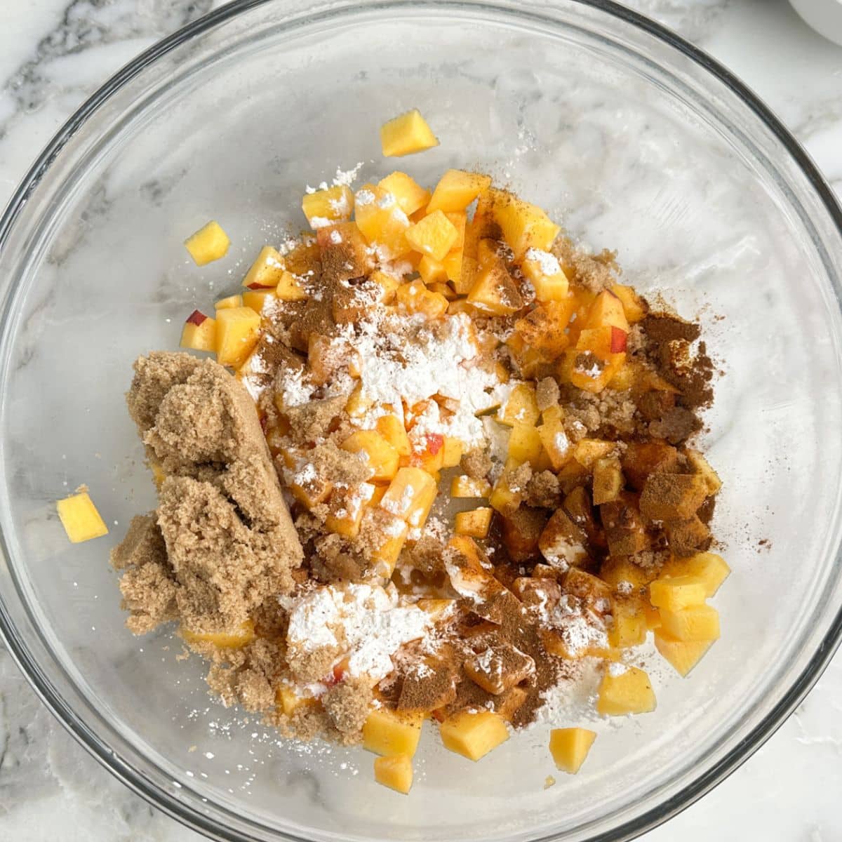 Bowl of brown sugar, diced peaches, cornstarch, and spices. 