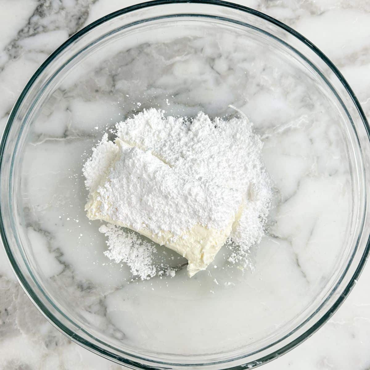 Bowl of cream cheese and powdered sugar. 