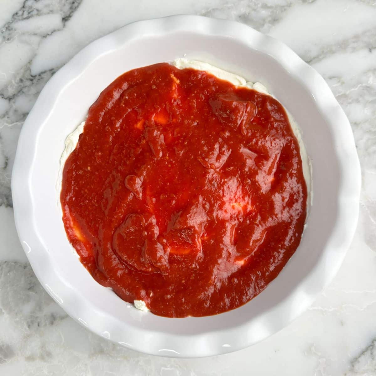 Baking dish with cream cheese and cocktail sauce. 
