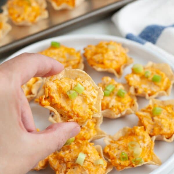 Hand holding a buffalo chicken dip bite.