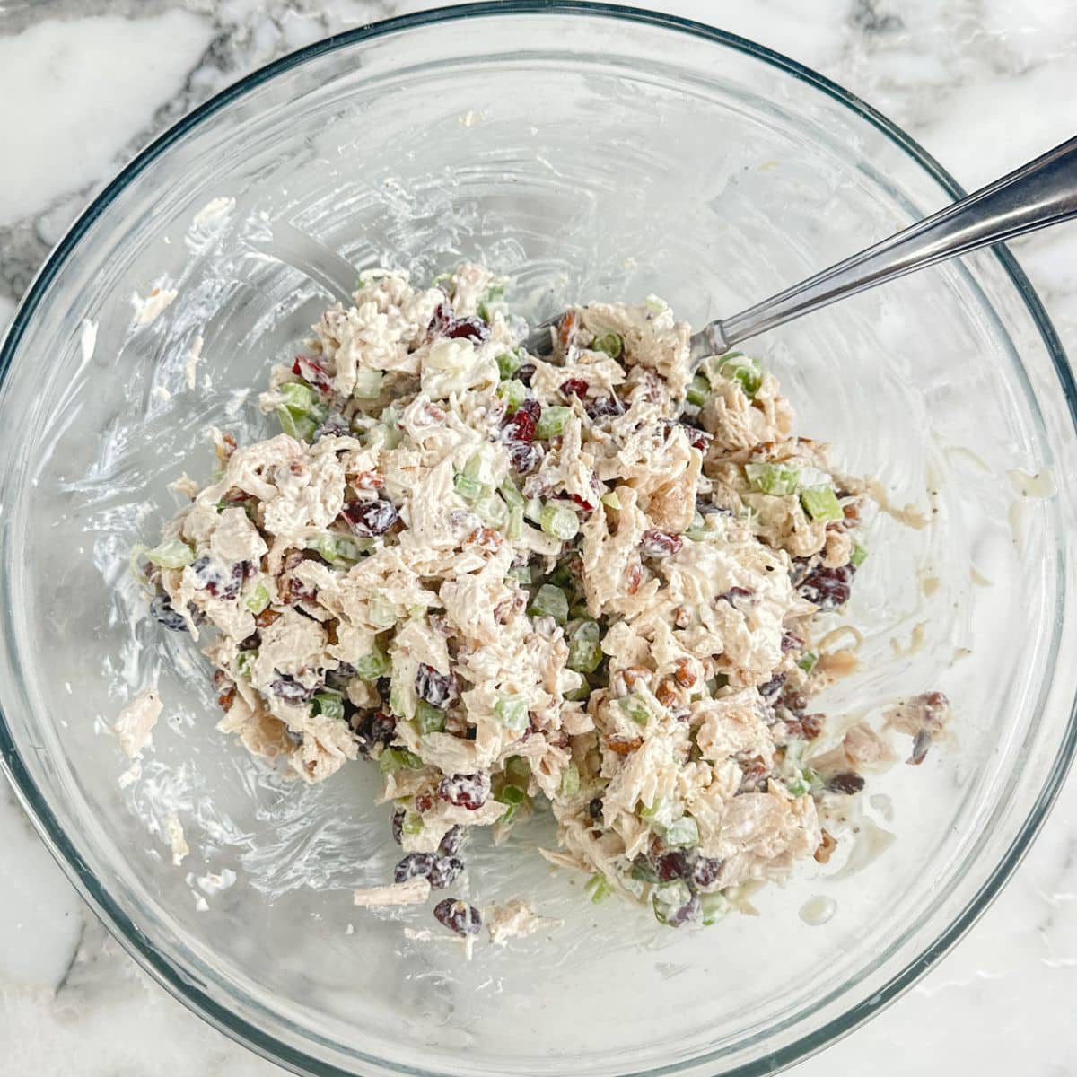 Bowl of cranberry chicken salad with a spoon.