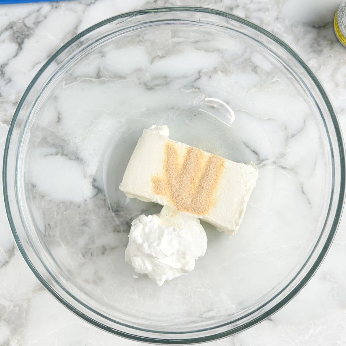 Bowl of cream cheese, garlic powder, and sour cream.