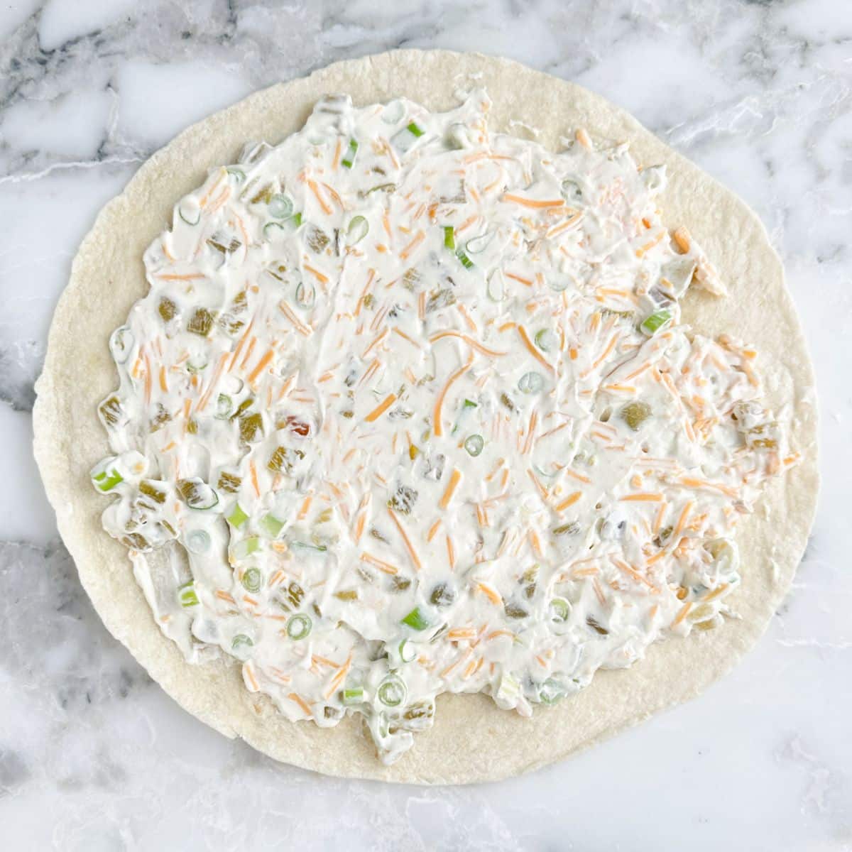 Flour tortilla topped with green chile cream cheese spread.