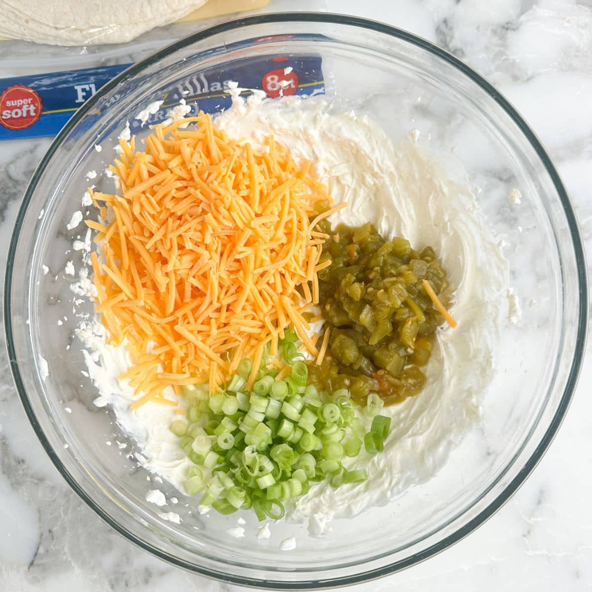 Bowl of shredded cream cheese, green chiles, and green onions.