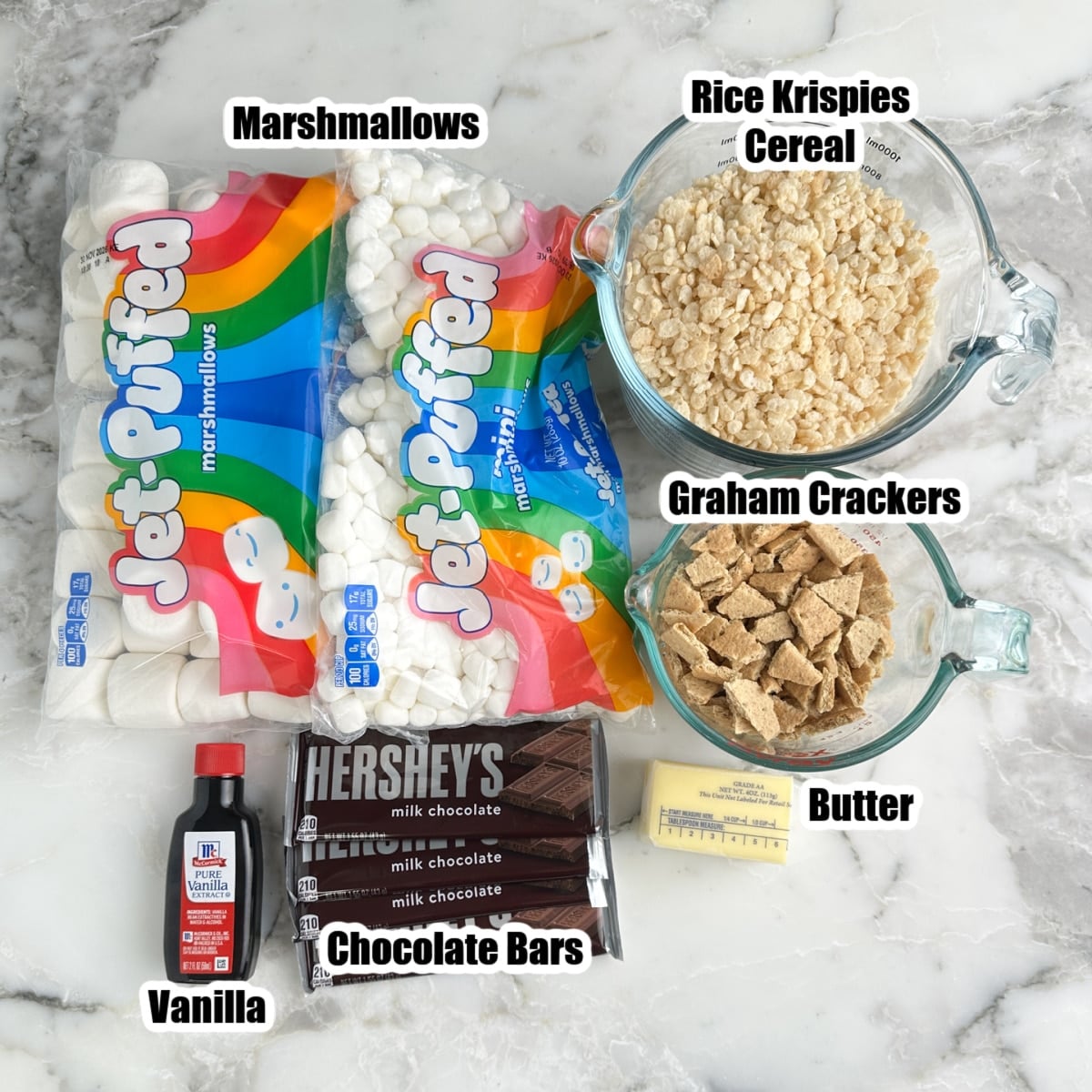 Bag of marshmallows, Rice Krispies, chocolate bars, broken graham crackers, vanilla, and butter.