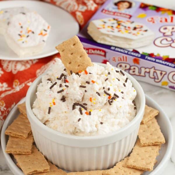 Bowl of Fall party cake dip with a graham cracker.