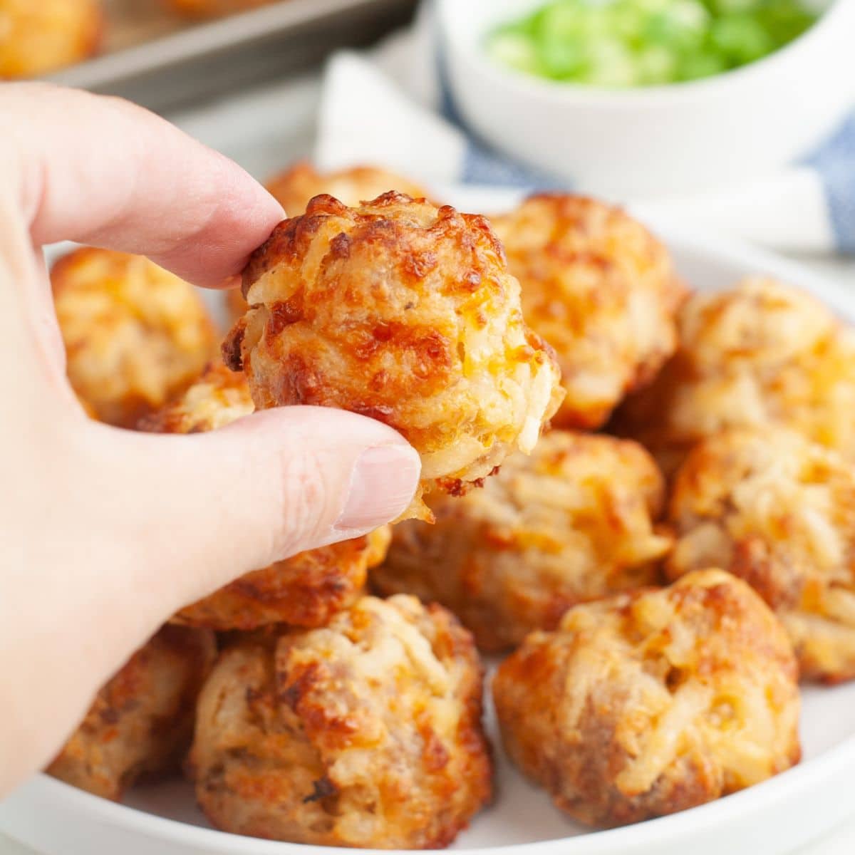 Hand holding a hash brown bite.