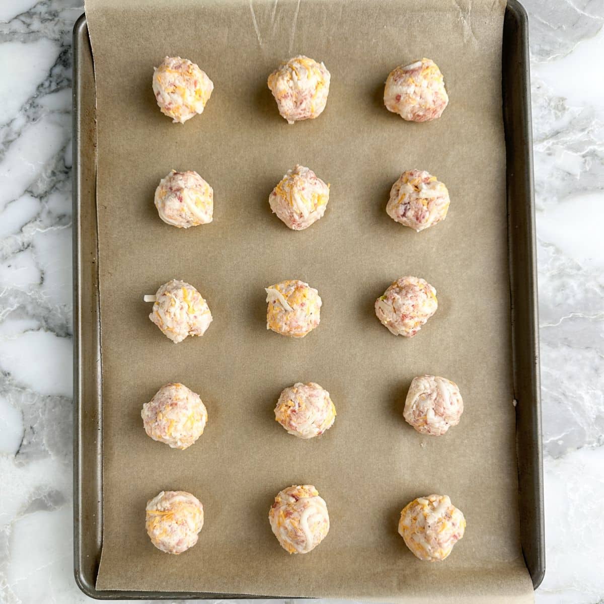 Baking dish with uncooked hash brown bites.