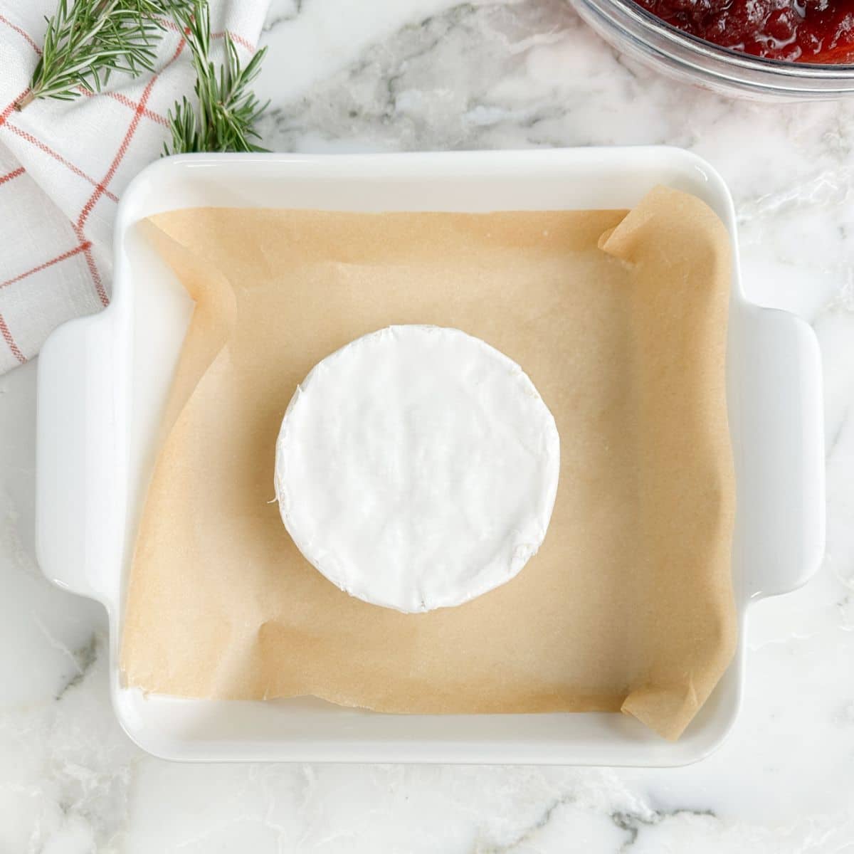 Wheel of brie in a baking dish.