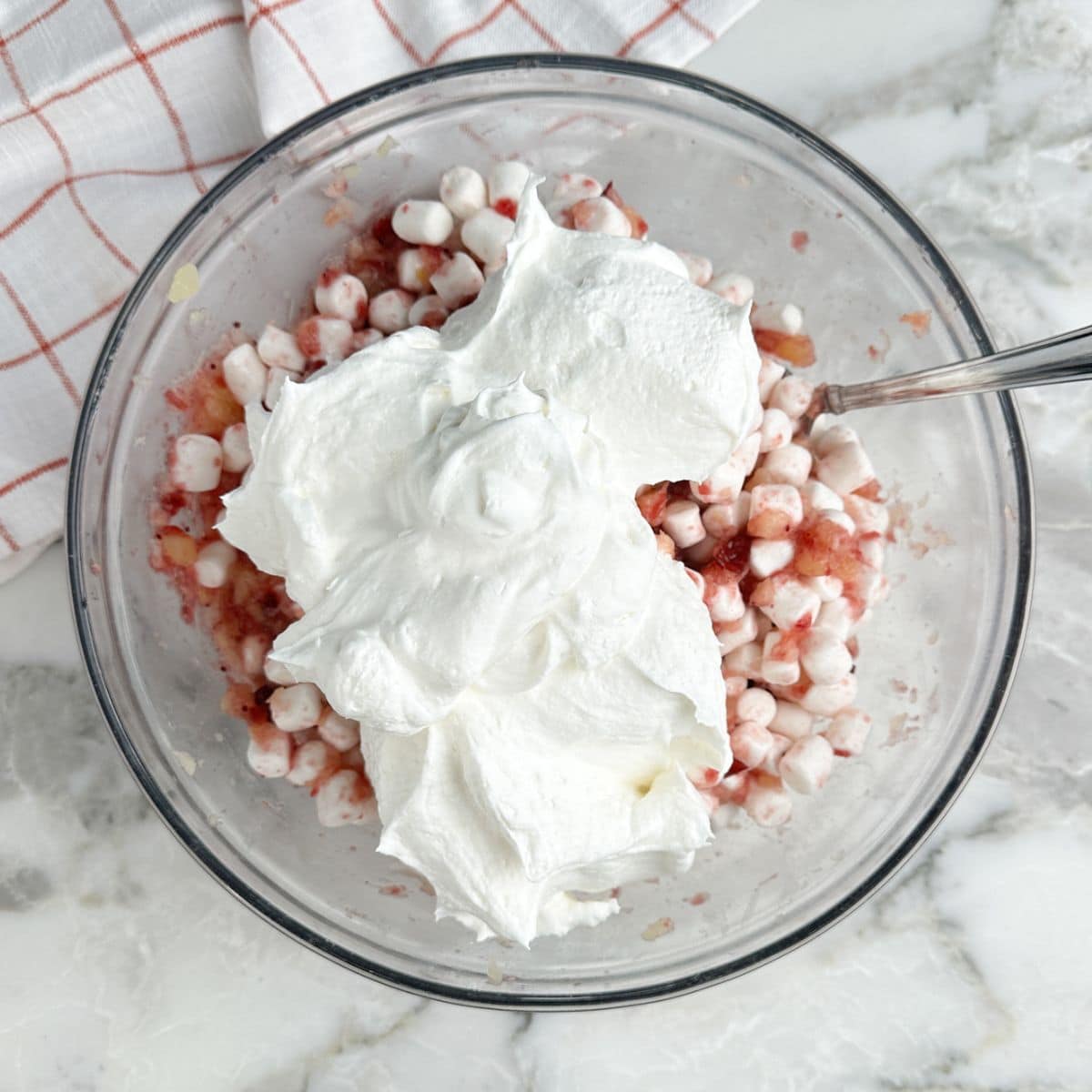 Bowl of crushed pineapple, cranberry jelly, and Cool Whip.