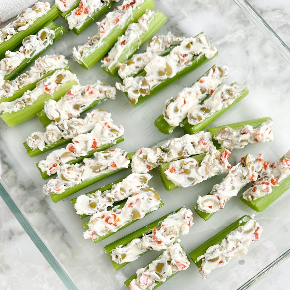Dish of cream cheese and olive stuffed celery sticks. 