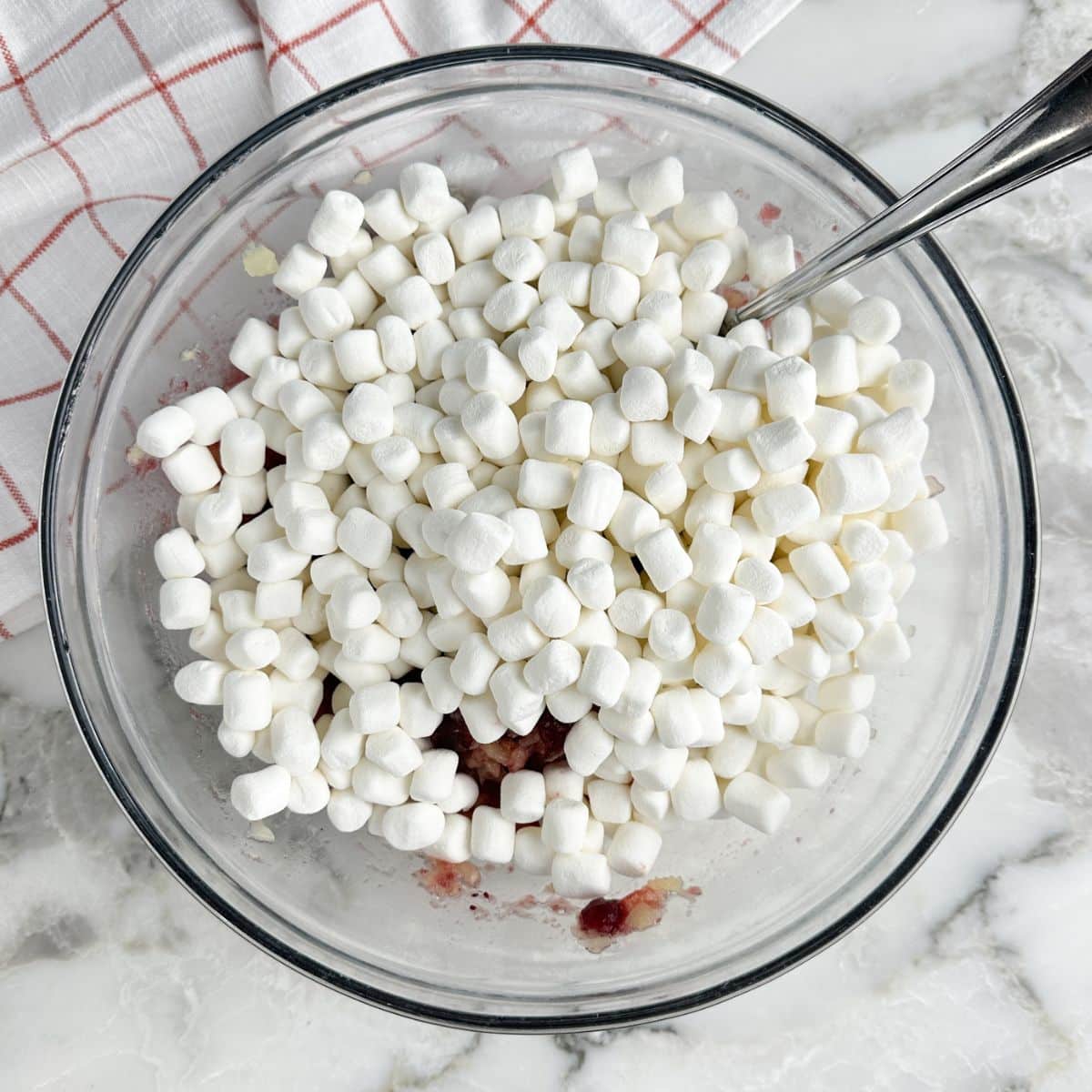Bowl with crushed pineapple, cranberry jelly, and mini marshmallows.