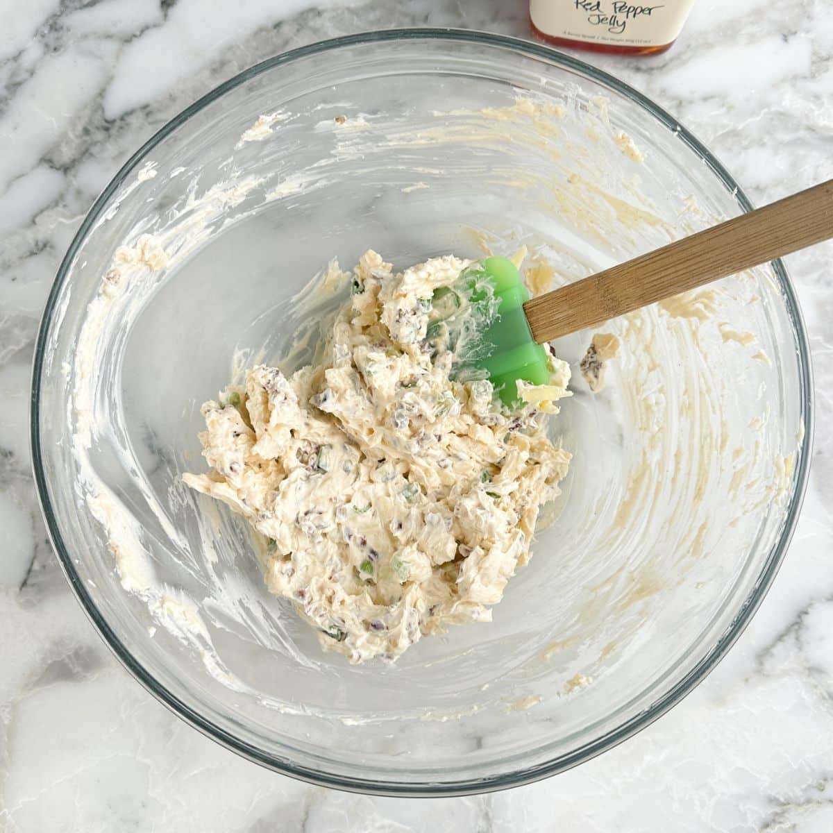 Bowl with whipped cream cheese mixture and spatula.