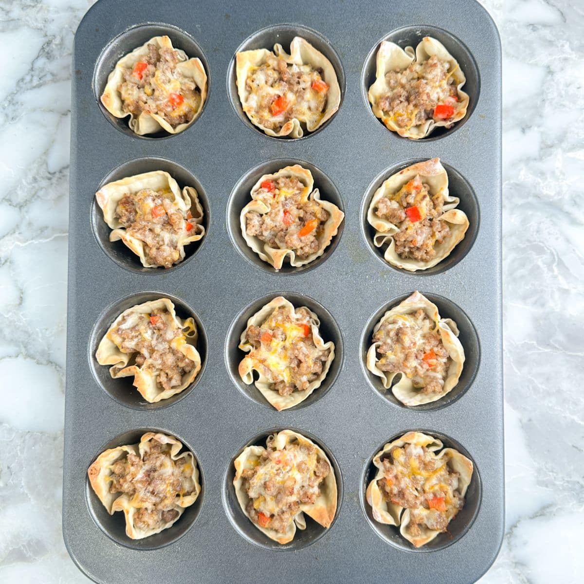 Sausage wontons in a muffin tin.
