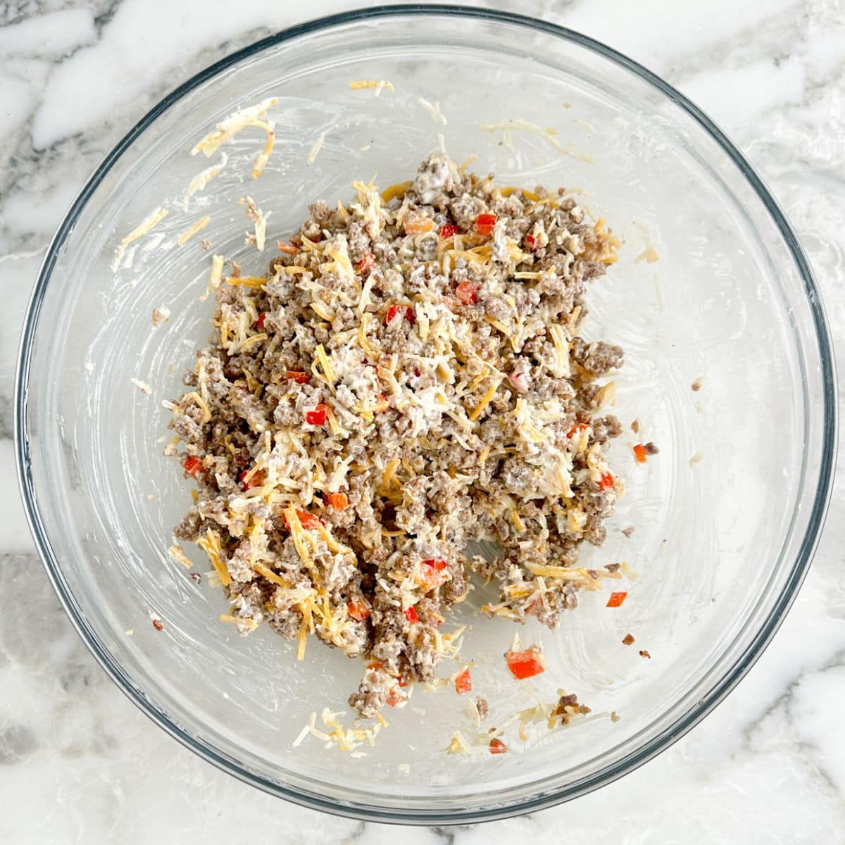 Bowl of sausage, cheese, and red peppers.